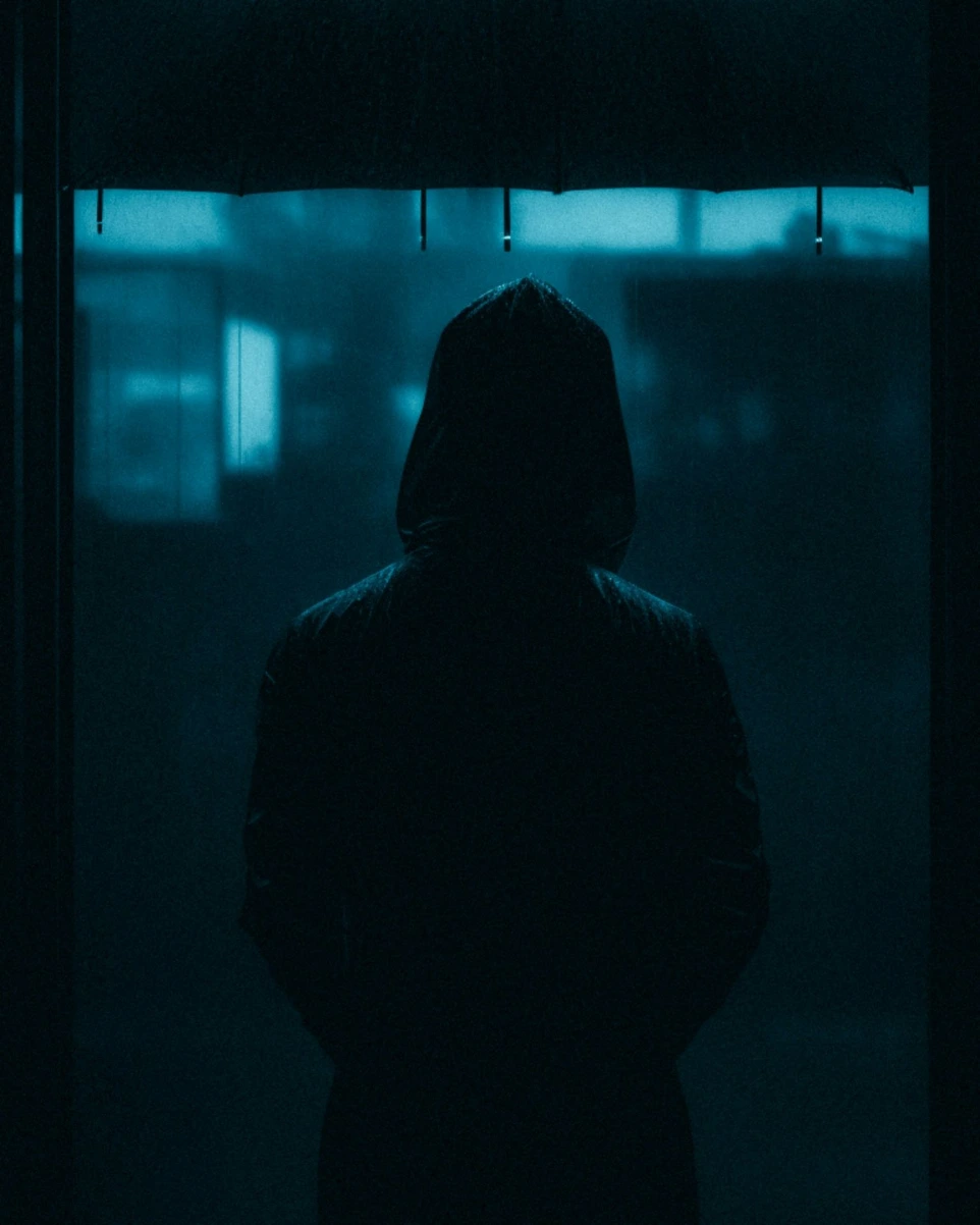 a person standing in a dark room with an umbrella